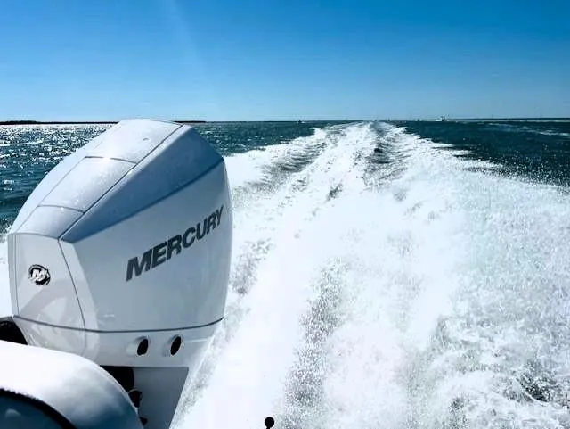 Slide: The Image of 2025 Glasstream 240 CCX boat with Mercury engine cruising on open water. - 7