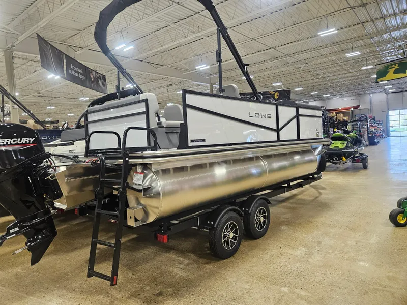 Slide: The Image of 2025 Lowe LS190 pontoon boat on trailer in showroom. - 1