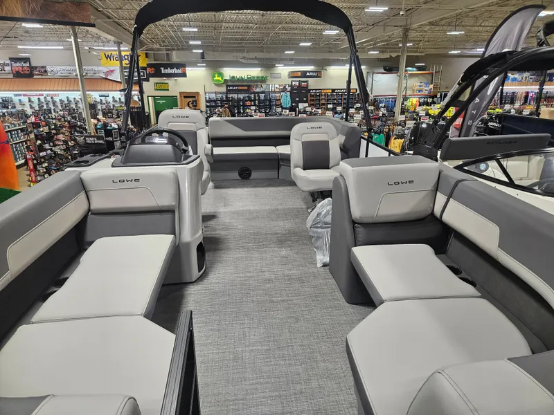 Slide: The Image of 2025 Lowe LS190 pontoon boat interior with spacious seating in a showroom. - 8