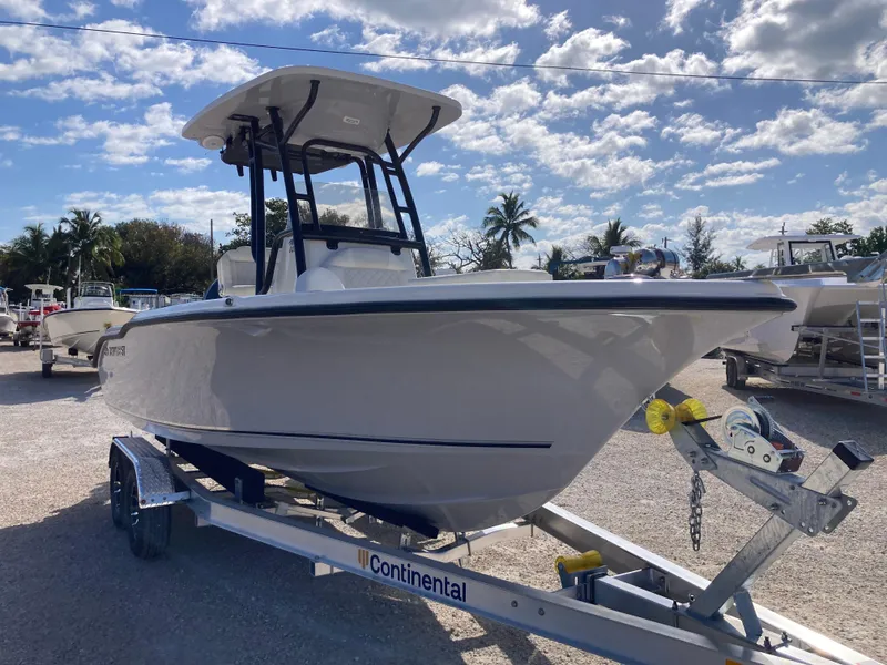 Slide: The Image of 2025 Key West 219fs boat on trailer under a partly cloudy sky. - 1