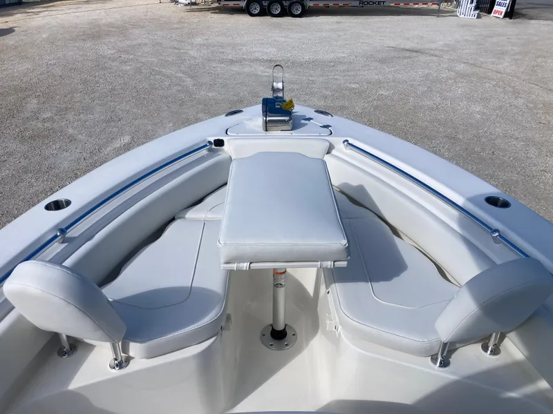 Slide: The Image of 2025 Key West 219fs boat interior with cushioned seating and table. - 10