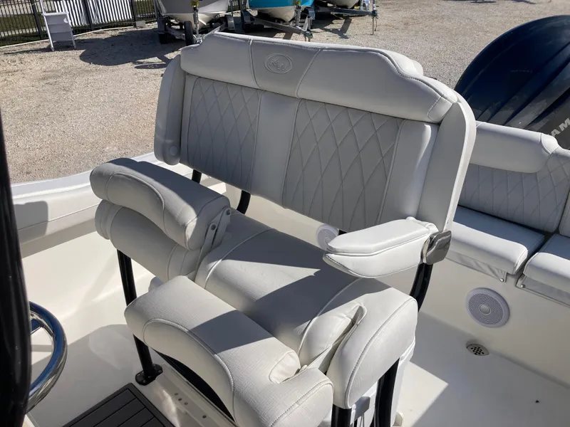 Slide: The Image of 2025 Key West 219fs boat seat with cushioned backrest and armrests in a marine setting. - 18