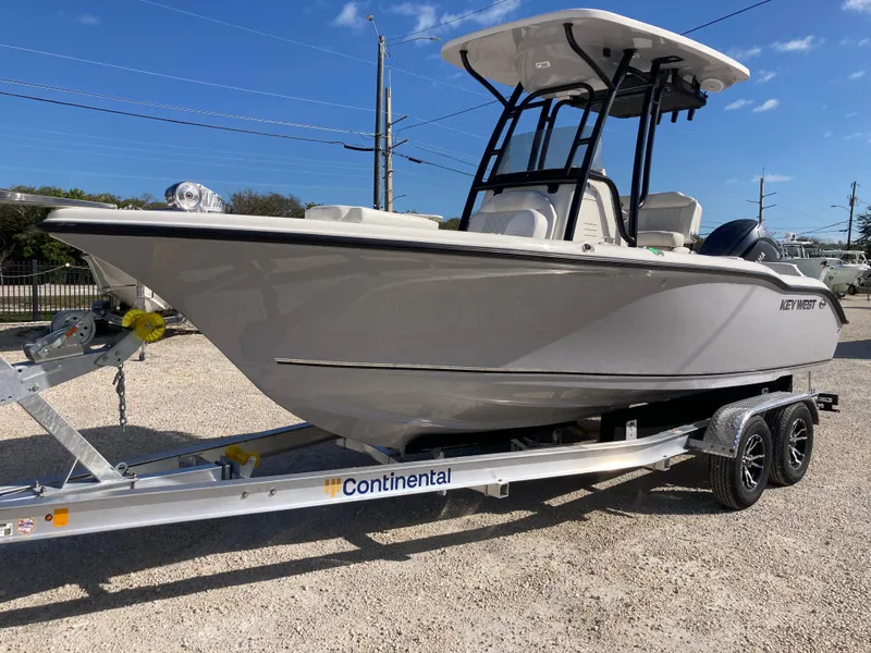 Slide: The Image of 2025 Key West 219fs boat on Continental trailer, parked outdoors under clear blue sky. - 5