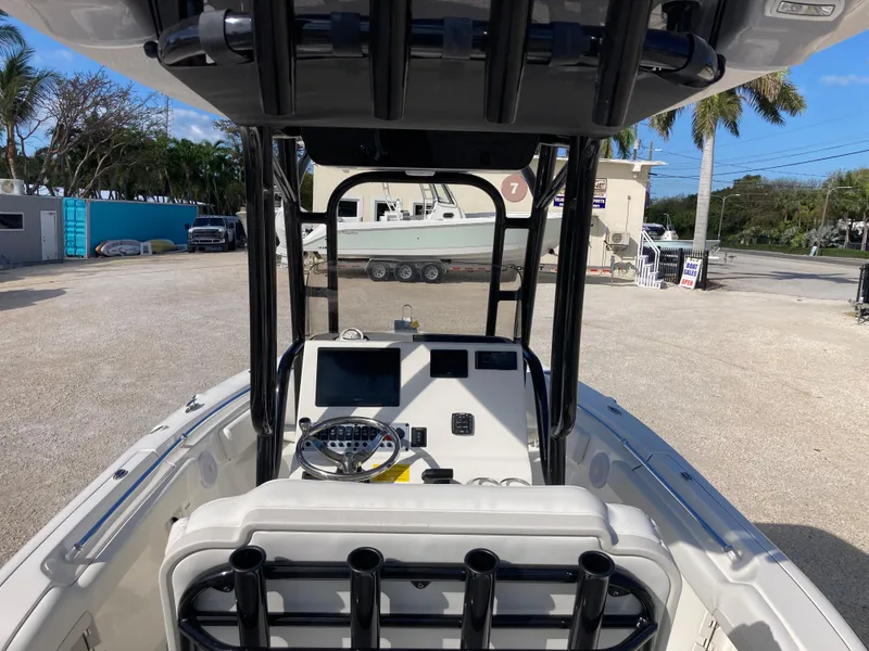 Slide: The Image of 2025 Key West 219fs boat interior with console and seating, parked outdoors. - 7