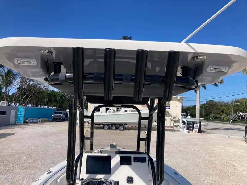 Slide: The Image of 2025 Key West 219fs boat with T-top and console, parked outdoors. - 8
