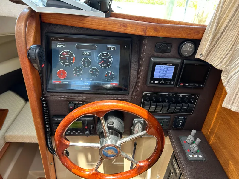 Slide: The Image of 2017 Ranger Tugs R-27 helm with wooden steering wheel and digital dashboard display. - 12