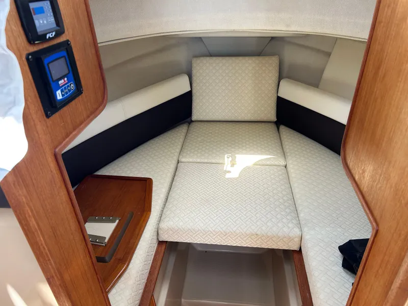 Slide: The Image of 2017 Ranger Tugs R-27 cabin interior with cushioned seating and wooden accents. - 18