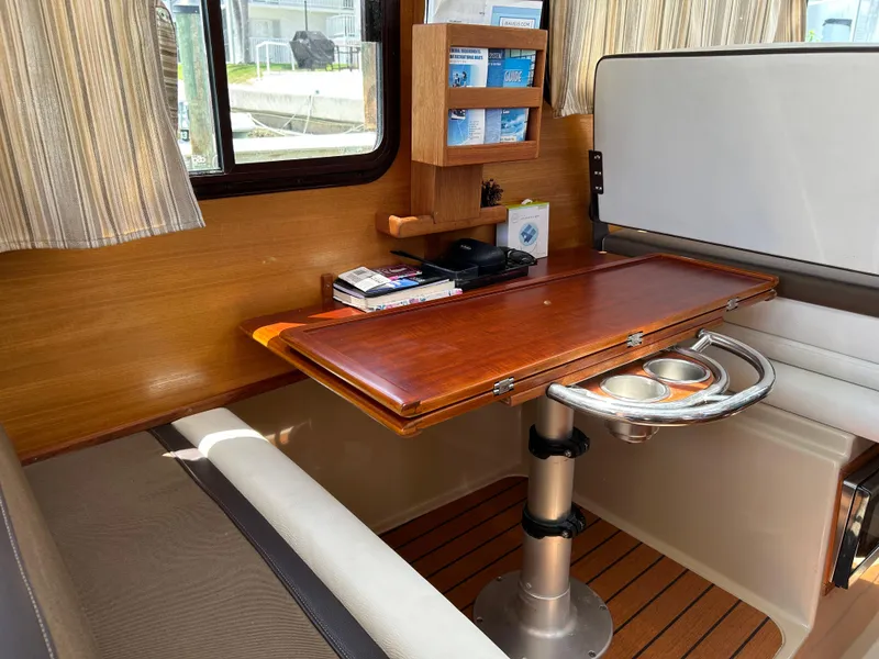 Slide: The Image of Interior of 2017 Ranger Tugs R-27 with wooden table and seating area. - 20