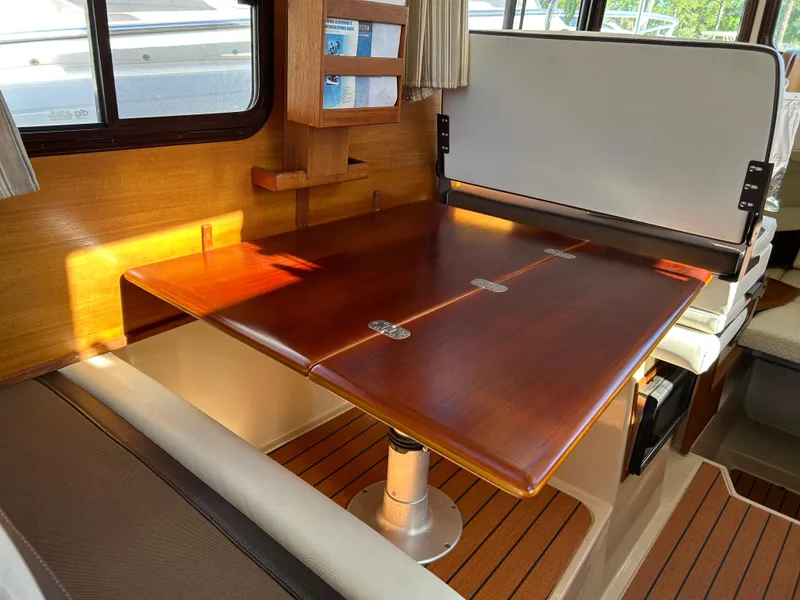 Slide: The Image of 2017 Ranger Tugs R-27 interior with wooden table and seating area. - 23