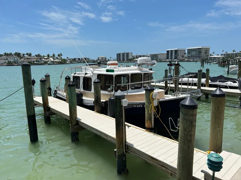 Slide: The Image of 2017 Ranger Tugs R-27 docked at a marina with clear blue skies. - 3