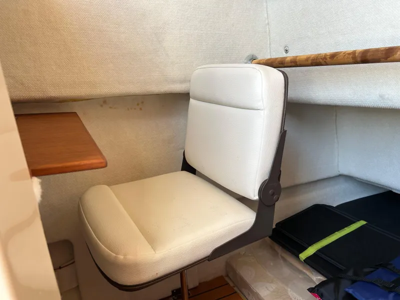 Slide: The Image of Interior of 2017 Ranger Tugs R-27 with white seat and wooden table. - 32