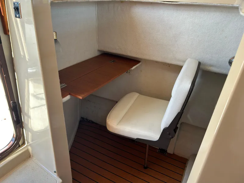 Slide: The Image of 2017 Ranger Tugs R-27 interior with a compact workspace and wooden flooring. - 33