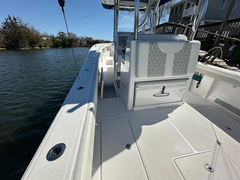 Slide: The Image of 2023 Front Runner 33 Center Console boat, sleek white deck, docked by calm waters. - 13