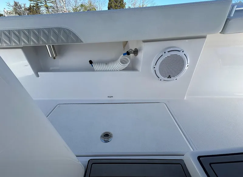 Slide: The Image of 2023 Front Runner 33 Center Console boat interior with speaker and hose storage. - 17