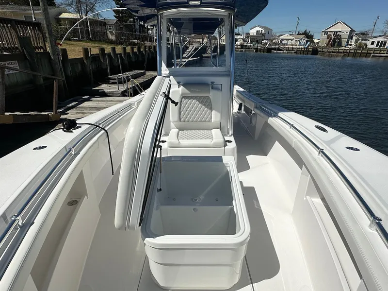 Slide: The Image of 2023 Front Runner 33 Center Console boat with open storage, docked by a waterfront. - 21