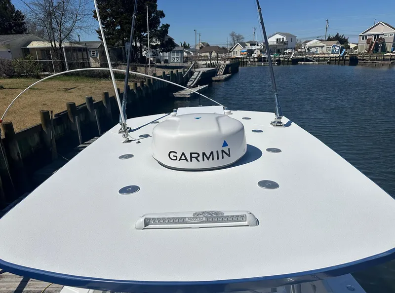 Slide: The Image of 2023 Front Runner 33 Center Console boat with Garmin radar on deck, docked by a canal. - 28
