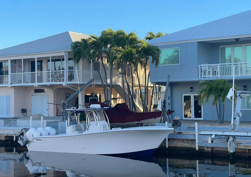 Slide: The Image of 2023 Front Runner 33 Center Console boat docked near waterfront homes. - 5