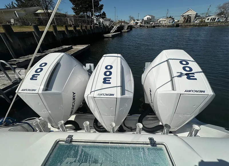 Slide: The Image of 2023 Front Runner 33 Center Console with triple Mercury 300 engines docked by the water. - 6