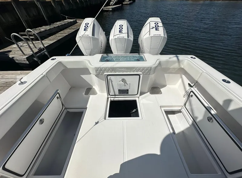 Slide: The Image of 2023 Front Runner 33 Center Console boat with triple outboard engines docked by the water. - 7