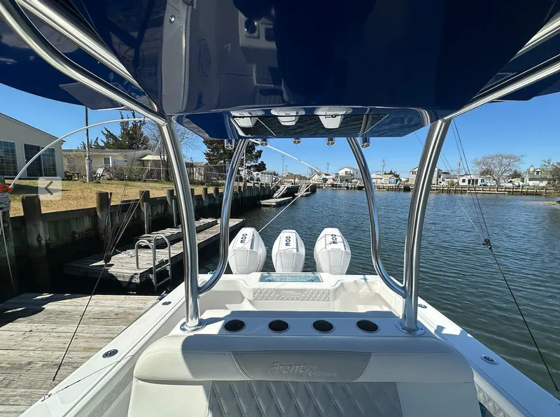 Slide: The Image of 2023 Front Runner 33 Center Console boat docked by a serene waterfront. - 9