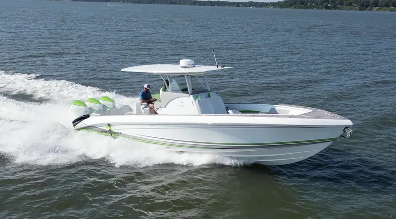 Slide: The Image of 2023 Statement 350 Open boat cruising on a lake with triple outboard engines. - 4