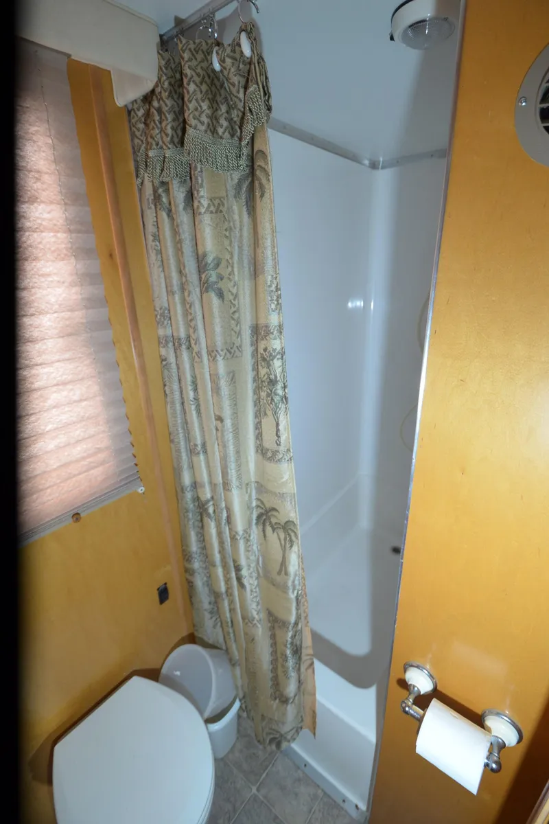 Slide: The Image of Compact bathroom with shower, tropical curtain, and toilet in 2008 Gibson 47 Classic. - 21