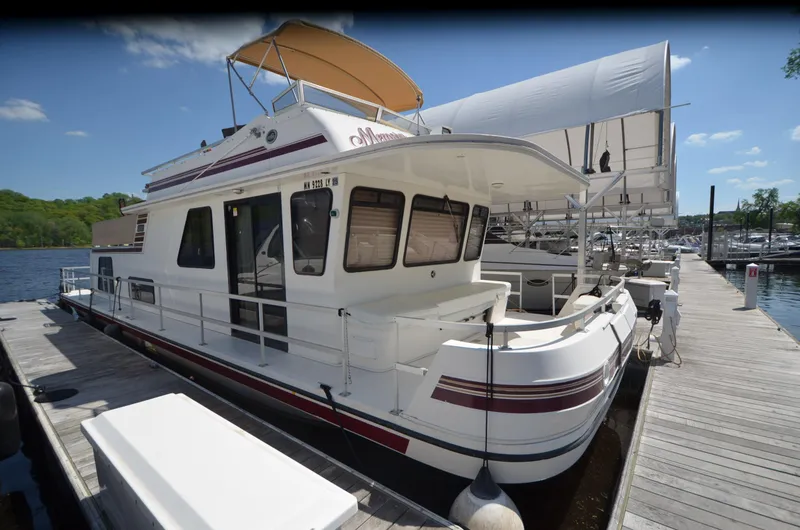 Slide: The Image of 2008 Gibson 47 Classic houseboat docked at marina under clear blue sky. - 23