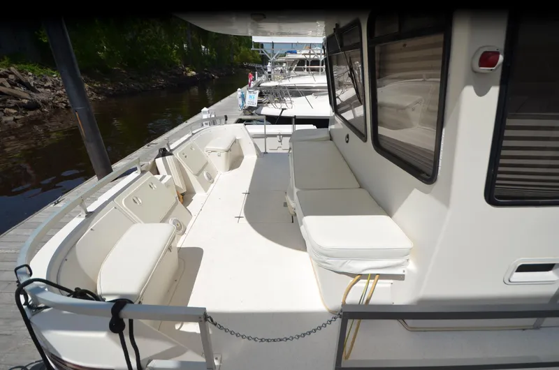 Slide: The Image of Spacious deck of 2008 Gibson 47 Classic boat with white seating and docked view. - 27