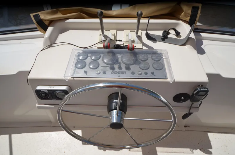 Slide: The Image of Steering wheel and controls of a 2008 Gibson 47 Classic boat. - 31