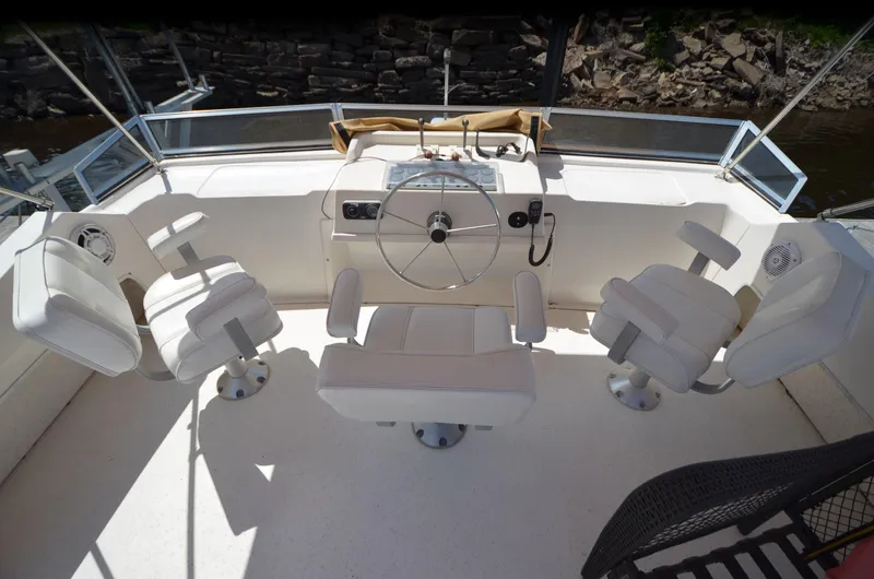Slide: The Image of Helm of 2008 Gibson 47 Classic boat with white seating and steering wheel. - 32