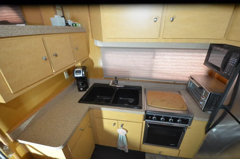 Slide: The Image of Compact kitchen in a 2008 Gibson 47 Classic, featuring modern appliances and ample storage. - 8