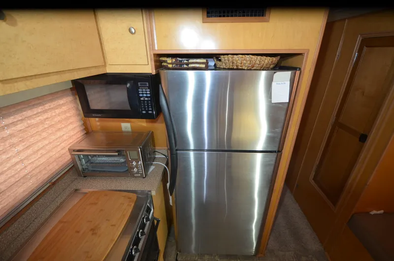 Slide: The Image of Compact kitchen with stainless steel fridge, microwave, and toaster oven in a 2008 Gibson 47 Classic. - 9