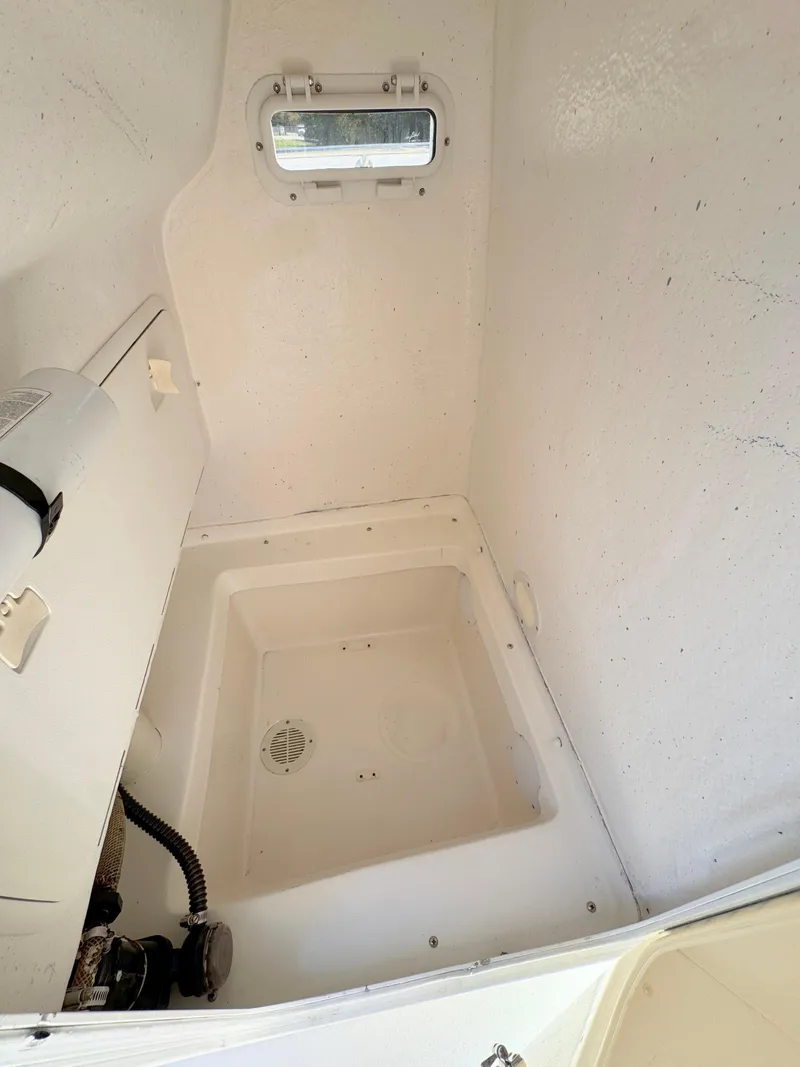 Slide: The Image of 2005 Sea Chaser 2100 Offshore boat interior with storage compartment and small window. - 11