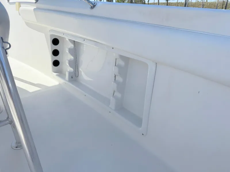Slide: The Image of 2005 Sea Chaser 2100 Offshore boat interior with storage compartments and rod holders. - 24