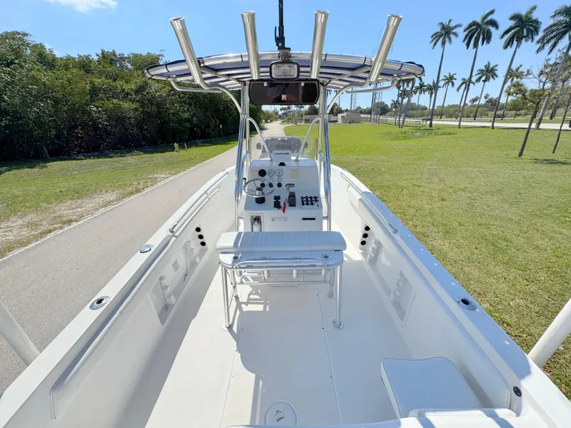 Slide: The Image of 2005 Sea Chaser 2100 Offshore boat with center console, open deck, and T-top, parked near palm trees. - 28