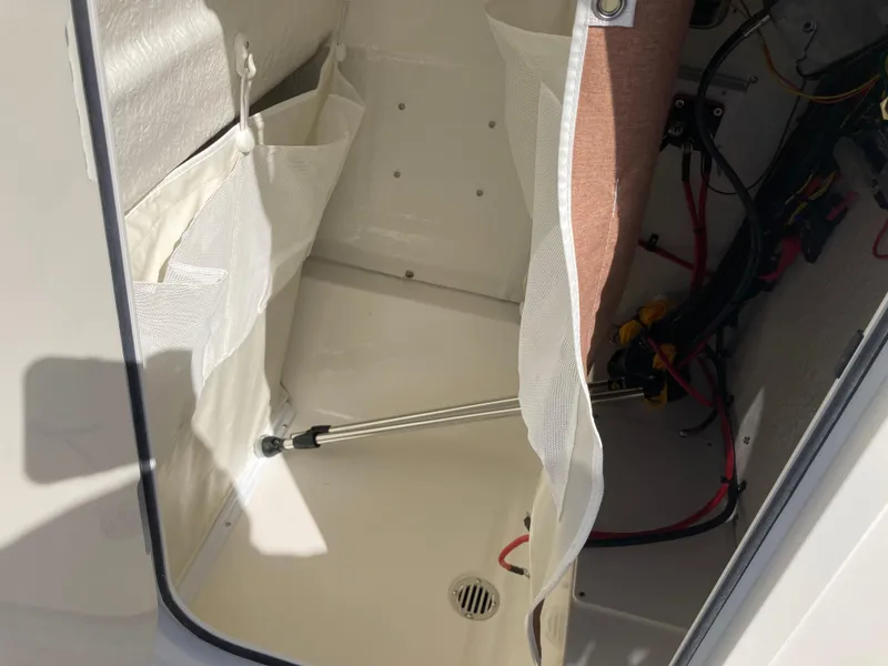 Slide: The Image of 2025 Key West 250BR boat storage compartment with mesh pockets and hydraulic support. - 15