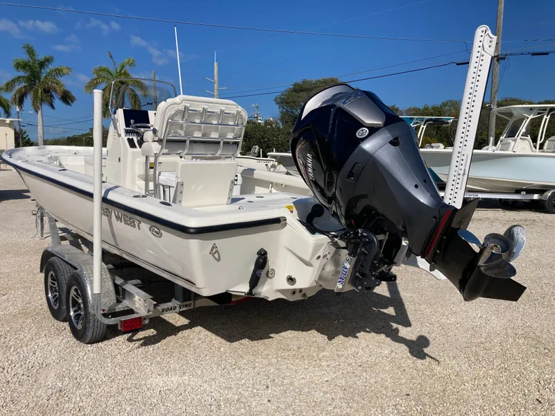 Slide: The Image of 2025 Key West 250BR boat on trailer with outboard motor, parked outdoors. - 4