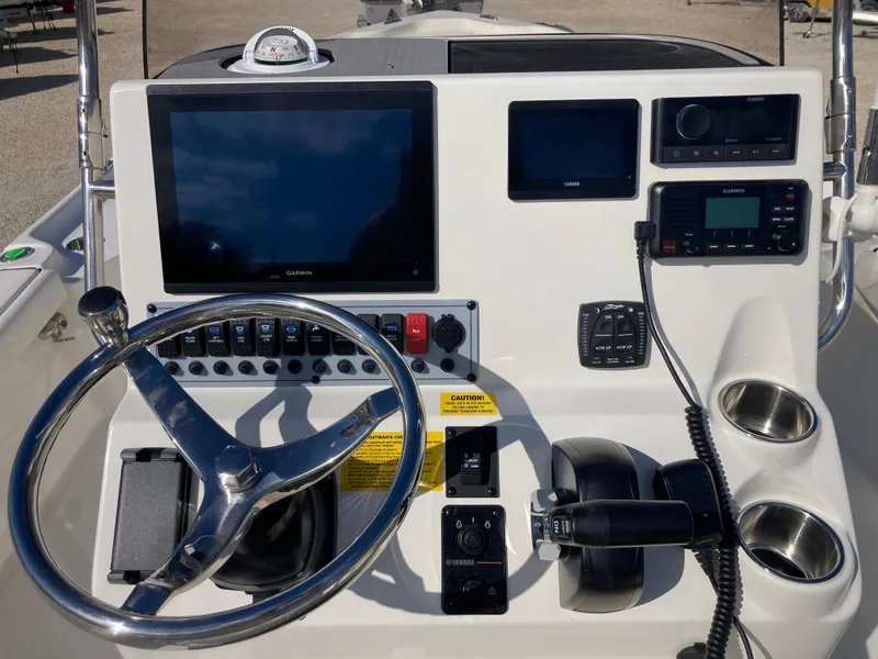 Slide: The Image of 2025 Key West 250BR boat dashboard with steering wheel, navigation screens, and controls. - 8