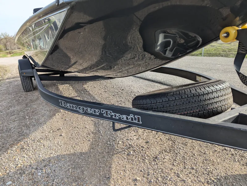 Slide: The Image of 2023 Ranger RT188P boat on Ranger Trail trailer, parked on gravel. - 10