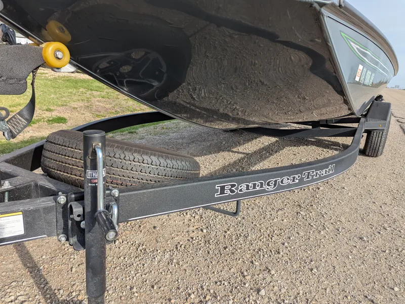 Slide: The Image of 2023 Ranger RT188P boat on a Ranger Trail trailer, parked on gravel. - 11