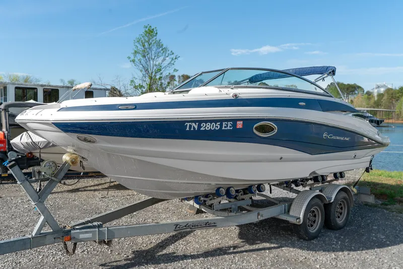 Slide: The Image of 2012 Crownline Eclipse E2 boat on trailer by a lake. - 1