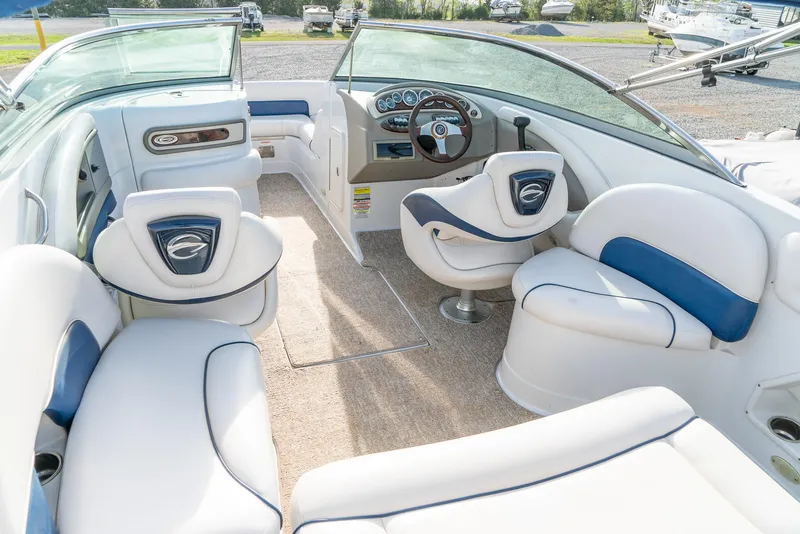 Slide: The Image of 2012 Crownline Eclipse E2 boat interior with white and blue seating, steering wheel, and dashboard. - 11