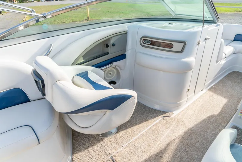 Slide: The Image of 2012 Crownline Eclipse E2 boat interior with white and blue seating, dashboard, and carpeted flooring. - 18
