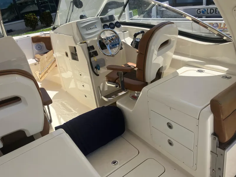 Slide: The Image of 2015 Scout 275 Dorado boat interior with helm, seating, and storage compartments. - 10