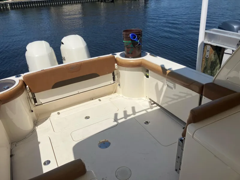 Slide: The Image of 2015 Scout 275 Dorado boat deck with seating, docked by the water. - 11