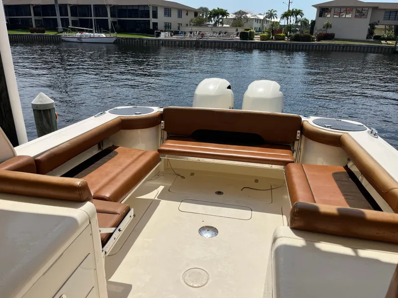 Slide: The Image of 2015 Scout 275 Dorado boat with brown seating, docked by waterfront homes. - 13