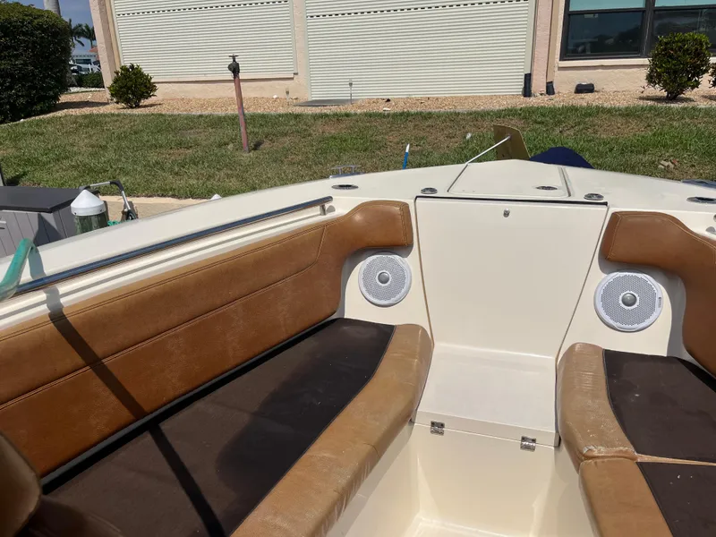 Slide: The Image of 2015 Scout 275 Dorado boat interior with tan seating and built-in speakers. - 14