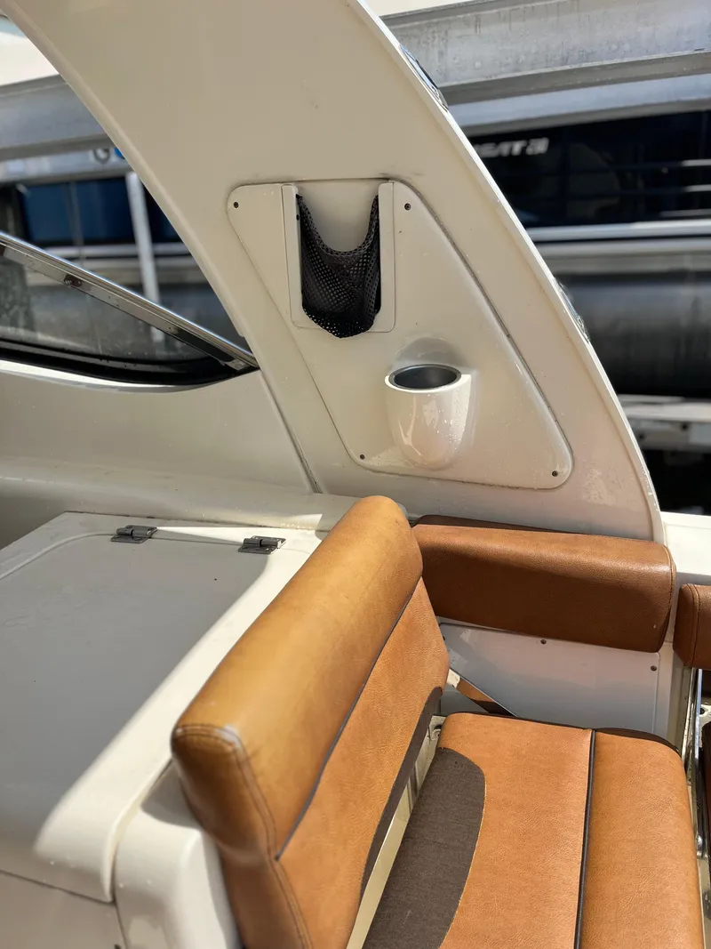 Slide: The Image of 2015 Scout 275 Dorado boat interior with tan seating and storage compartment. - 16