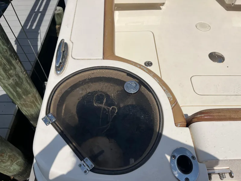 Slide: The Image of 2015 Scout 275 Dorado boat deck with storage compartment and coin on top. - 17