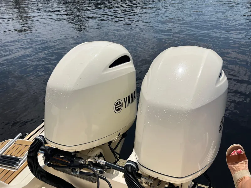 Slide: The Image of Twin Yamaha outboard motors on a 2015 Scout 275 Dorado boat, docked on calm water. - 21